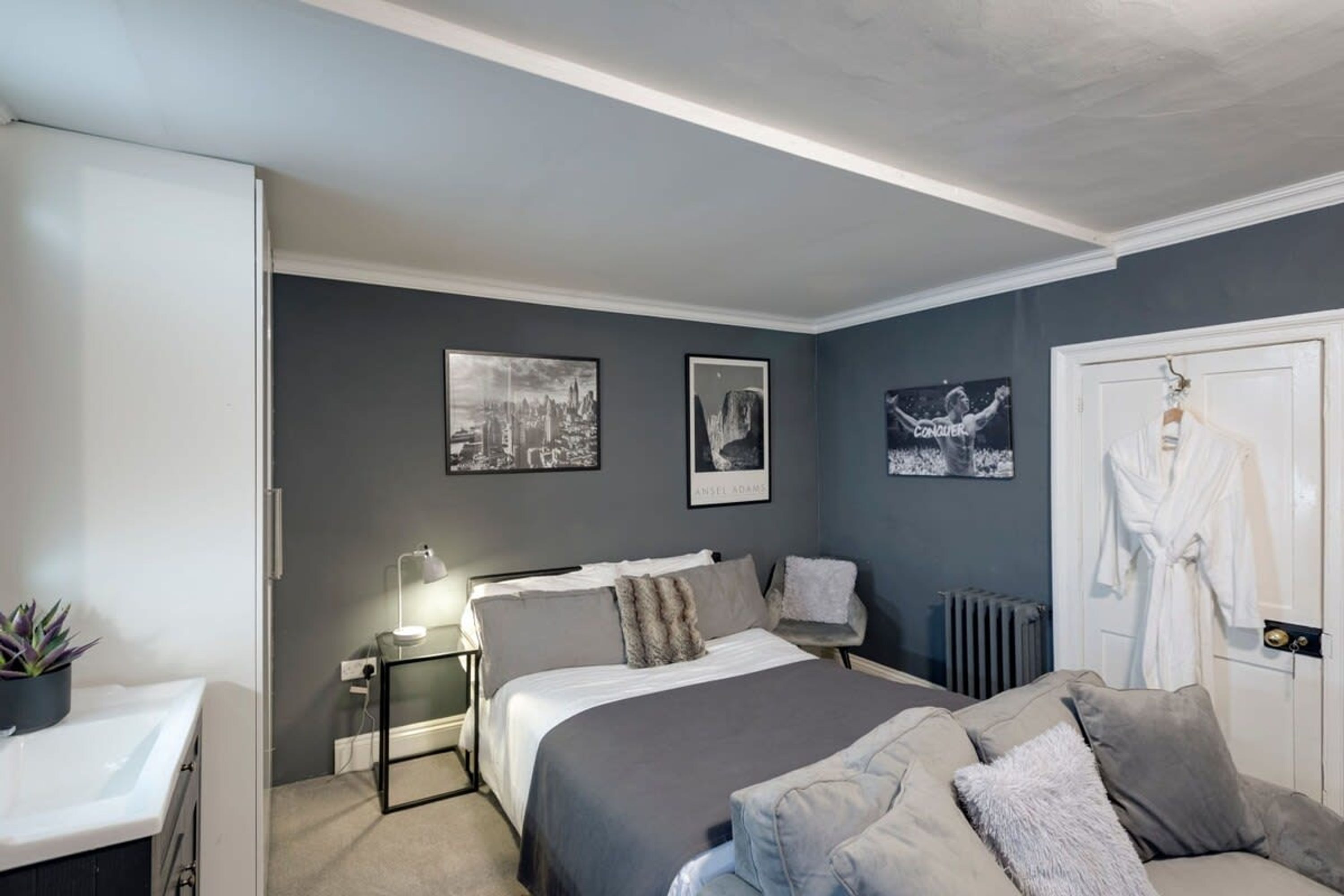 A modern bedroom with a bed, bedside table, and a radiator.
