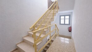 A staircase with yellow handrails leading to a landing.