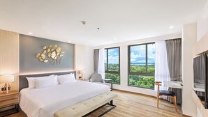 Una camera d'albergo moderna con un letto grande, una scrivania e una TV.
