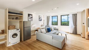 Un appartamento moderno con lavatrice, divano, scrivania e un'ampia finestra vista panoramica.