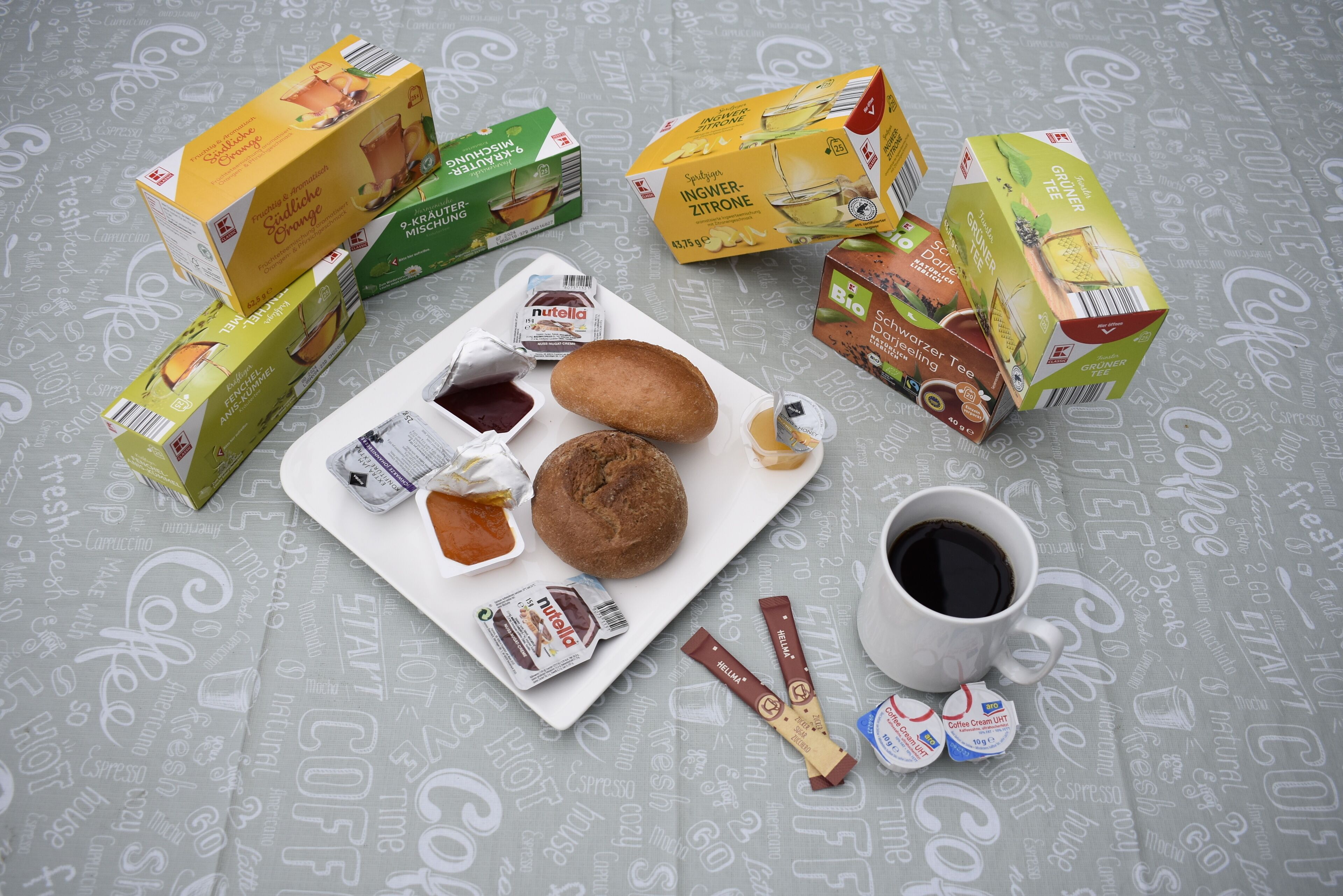 A breakfast setup with various food items and coffee products on a table.