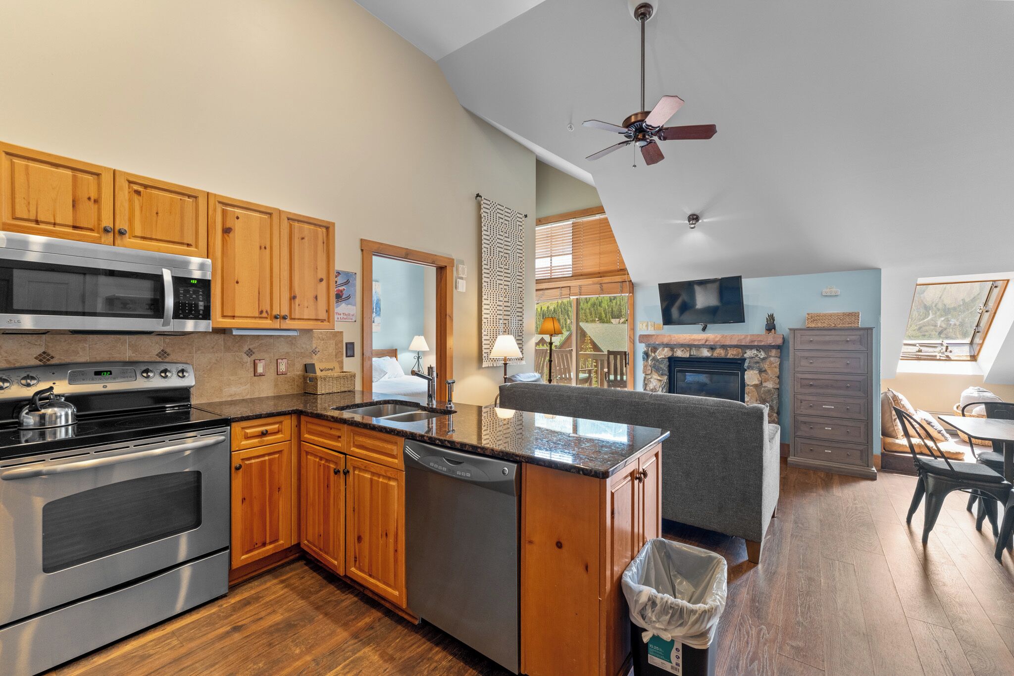 A spacious kitchen with wooden cabinets, a stainless steel stove, and a built-in microwave.