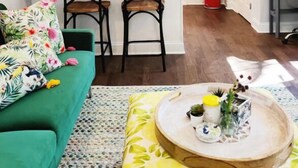 A modern kitchen with white cabinets, a wooden island, and a red trash bin. - 2227 Locust (Philadelphia)
