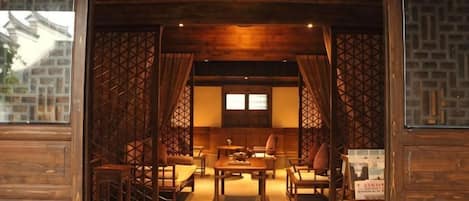Un interior tradicional con techo de madera, una mesa central y disposición de asientos.