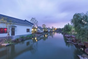 Un cuerpo de agua tranquilo con edificios tradicionales a un lado.
