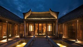 A traditional courtyard with a central building, possibly a reception or lobby, flanked by two wings.