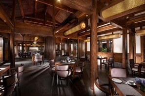 A restaurant interior with wooden beams, round tables, and chairs. - GRAND HOUSE NINGBO (Ningbo)