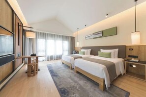 A modern hotel room with two beds, a desk, and a large window with curtains. - GRAND HOUSE NINGBO (Ningbo)