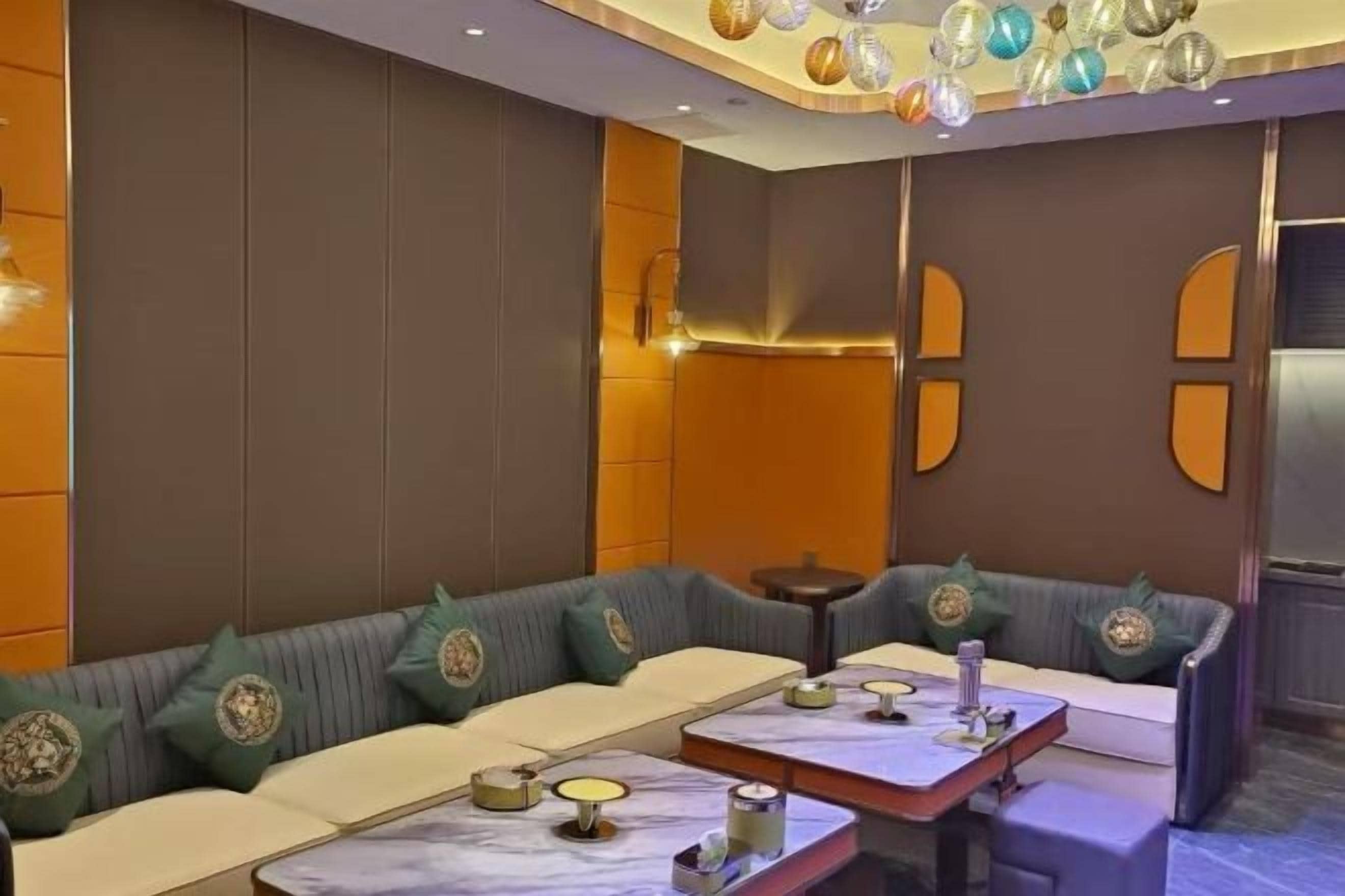 A modern interior with a sofa set, tables, and decorative wall elements.