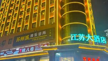 A hotel with multiple floors, illuminated signage, and a prominent vertical structure.