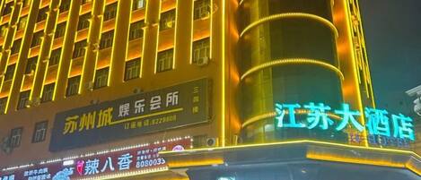 A hotel with multiple floors, illuminated signage, and a prominent vertical structure.