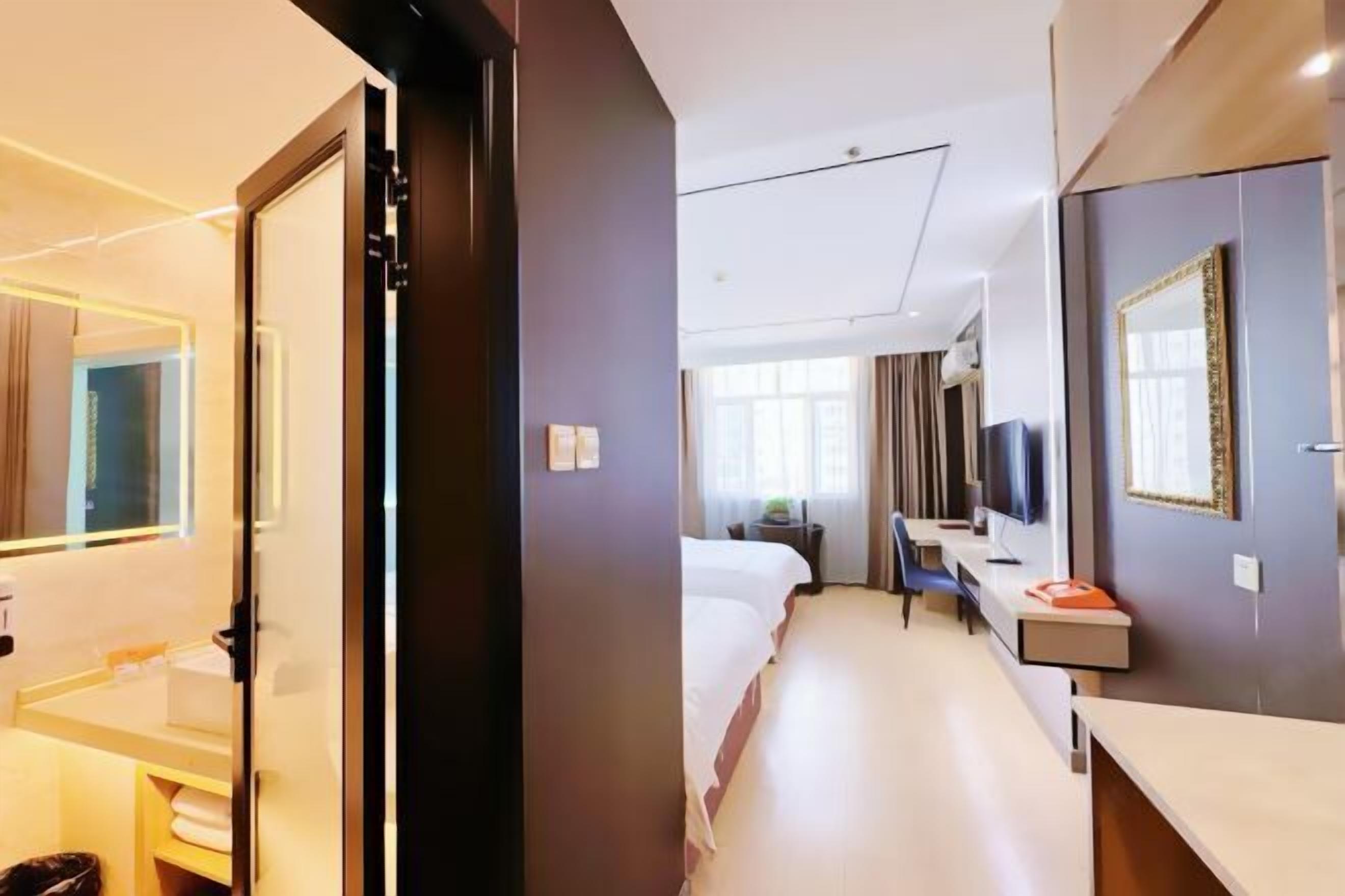 Una habitación de hotel con cama, mesita de noche, televisión y ventana.