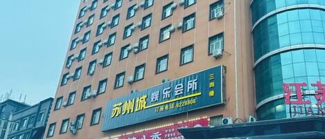 Un edificio de varios pisos con letreros de un restaurante y un hotel.