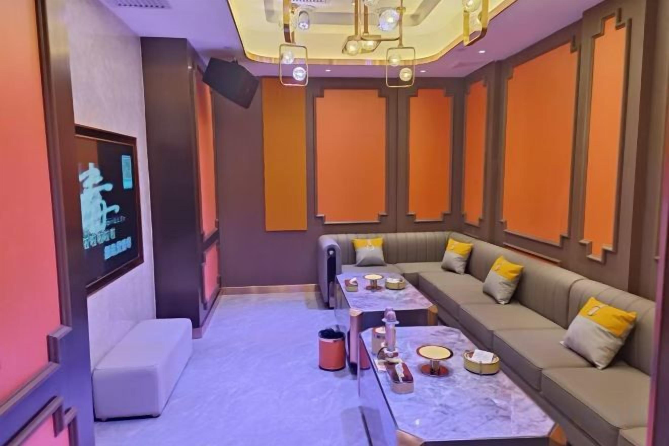 Een moderne hotelkamer met een zithoek, een flatscreen televisie en een marmeren tafel.