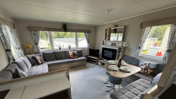 A compact living space with a sofa, a dining table set for four, a TV, and a fireplace. - West Lawn 47 Haggerston Castle Paddock Views (Berwick-upon-Tweed)