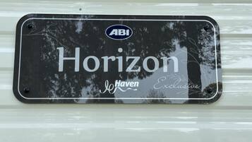 Una placa de matrícula negra con la inscripción 'Horizon' y 'Haven Exclusive' sobre un fondo blanco.