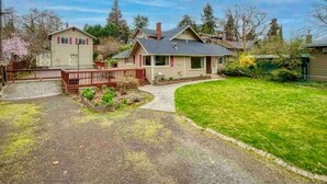 A residential house with a well-maintained lawn, a driveway, and a fenced backyard. - Medford Home and 2 Condos With Pool and Hot tub (Medford)