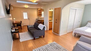 A spacious living area with a sofa, a dining table, and a kitchen in the background. - Medford Home and 2 Condos With Pool and Hot tub (Medford)