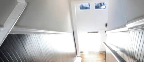 En trappa som leder upp till en dörr med ett litet fönster ovanför.