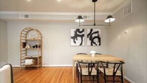 A dining area with a wooden table and chairs, a ladder shelf, and abstract art on the wall. - 405 S 20th  (Philadelphia)