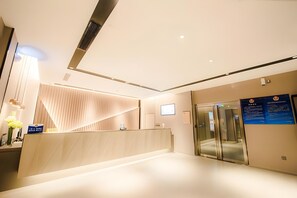 A modern reception area with a reception desk, a digital screen, and a glass elevator. - Homeinn Selected Hotel (Beijing Beixinqiao Nanluoguxiang) (Beijing)