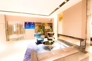 A modern lobby with a seating area, a fireplace, and a reception desk. - Homeinn Selected Hotel (Beijing Beixinqiao Nanluoguxiang) (Beijing)