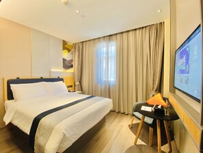 A hotel room with a bed, a desk, a chair, a television, and a window with curtains. - Homeinn Selected Hotel (Beijing Beixinqiao Nanluoguxiang) (Beijing)