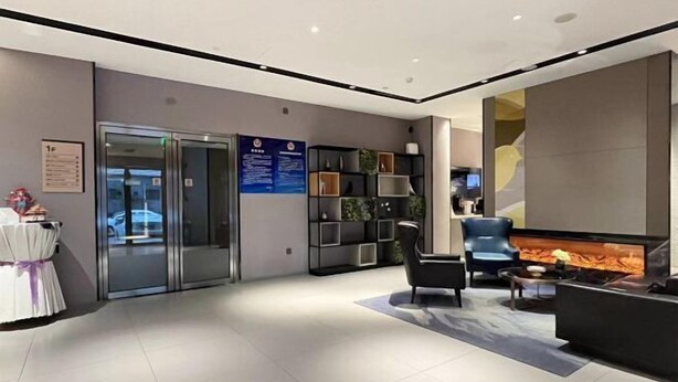 A modern lobby with a reception desk, seating area, and a fireplace. - Homeinn Selected Hotel (Beijing Beixinqiao Nanluoguxiang) (Beijing)