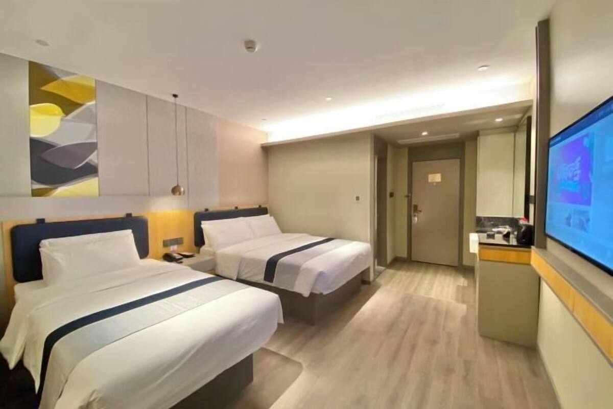 Une chambre d’hôtel avec deux lits, une télévision, un bureau et une salle de bain.