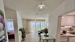 A modern kitchen with a dining area, a large window, and a ceiling light fixture. - Lido Branca by Olá Madeira (Funchal)