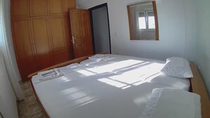 A bedroom with a bed, a wardrobe, and a window.