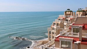 Ein Küstenhotel mit mehreren Balkonen mit Blick auf das Meer.
