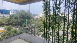 Ein geräumiger Balkon mit freiem Blick auf die Stadt, einschließlich Gebäude und Bäume.