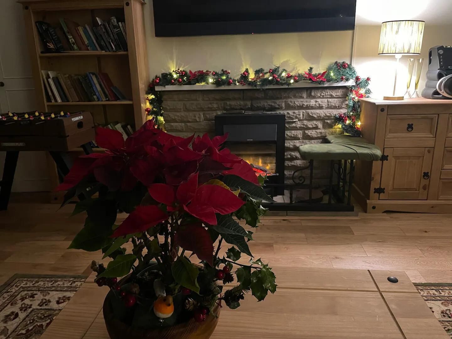 A cozy living room with a fireplace, a bookshelf, and a coffee table.