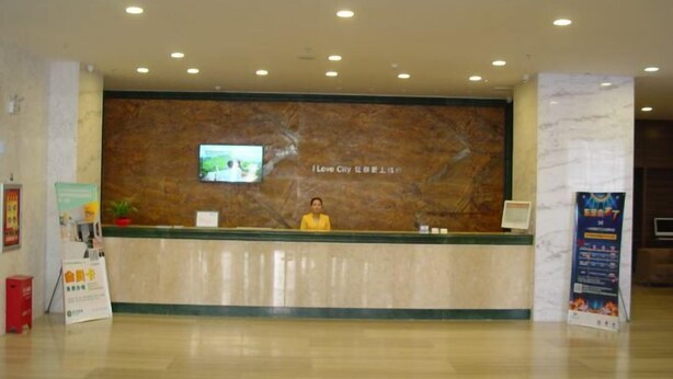 A hotel reception area with a marble counter, a television screen, and a receptionist. - Nileke Echarm Hotel (Nilka County)