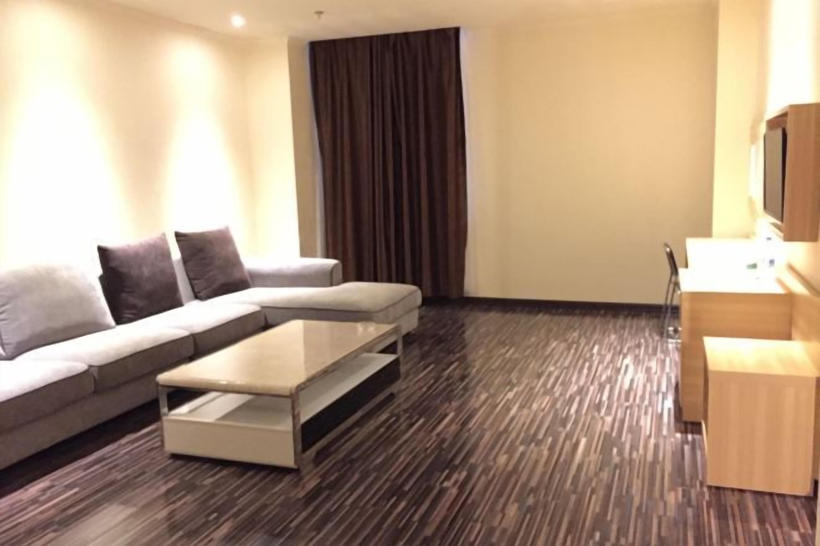 A modern living room with a sofa, a coffee table, and a TV stand.