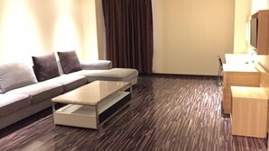 A modern living room with a sofa, a coffee table, and a TV stand.