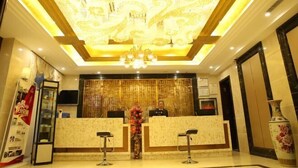 A hotel reception area with a chandelier, a reception desk, and a large vase of flowers. - Fengda Vista Hotel (Wuwei No.2 Middle School Pedestrian Street) (Wuwei)