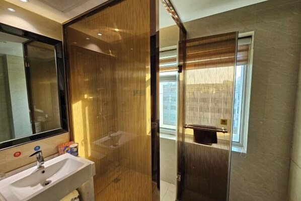 Une salle de bain avec un séparateur en bois, un lavabo et une fenêtre donnant sur un beau paysage.