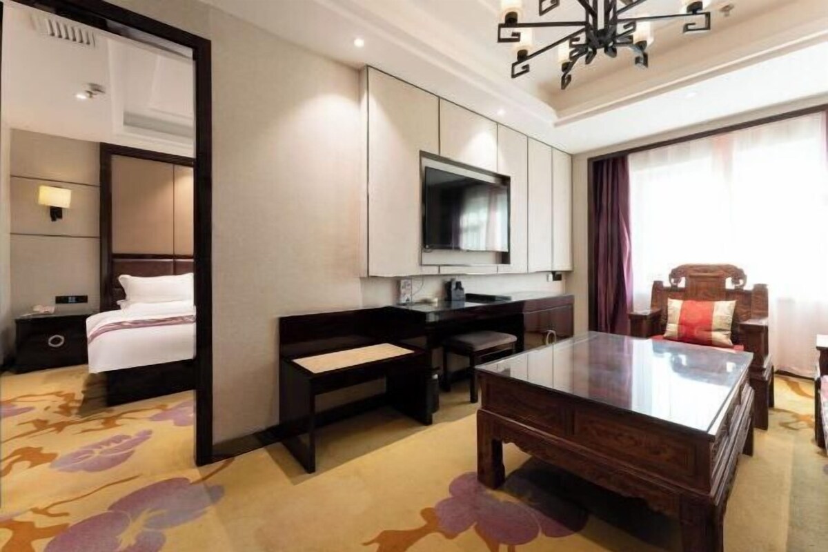 Une chambre d’hôtel équipée d’un lit, d’un bureau, d’une télévision et d’une table à manger.