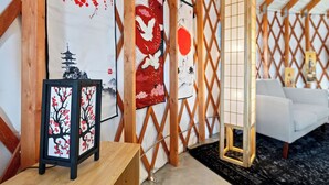 A room with a traditional Japanese-style interior, including a tatami mat floor, a low wooden table, and a white sofa.