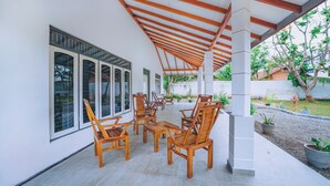 Une terrasse extérieure avec des meubles en bois et un espace abrité doté d’un plafond en bois.