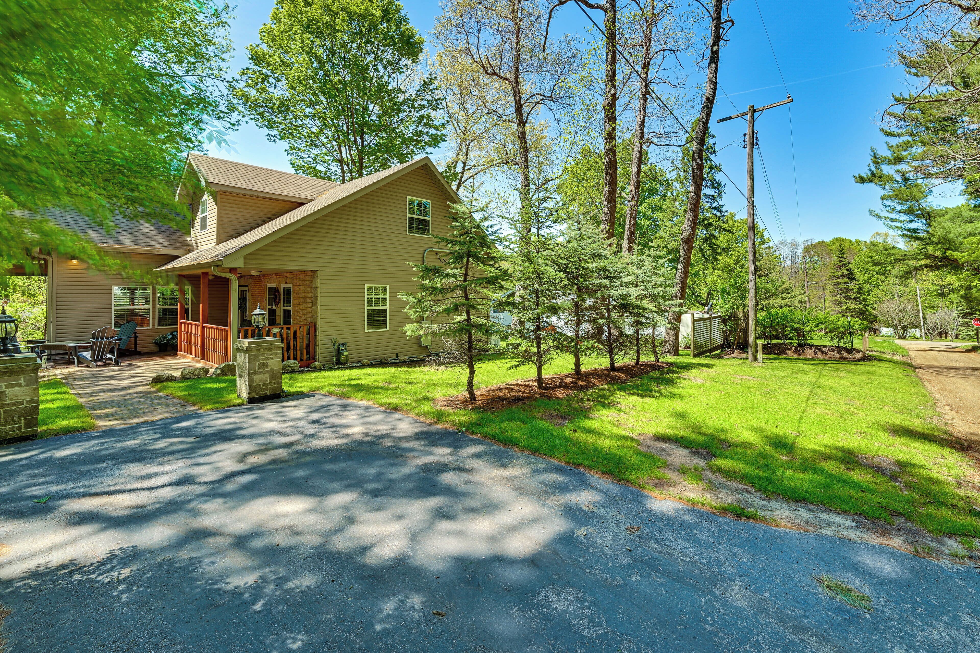 A two-story house with a front porch, a driveway, and a well-maintained lawn.