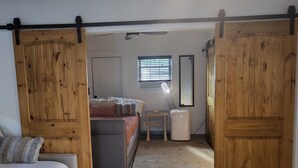 Une chambre à coucher avec un lit, une table de chevet, un miroir et un radiateur.