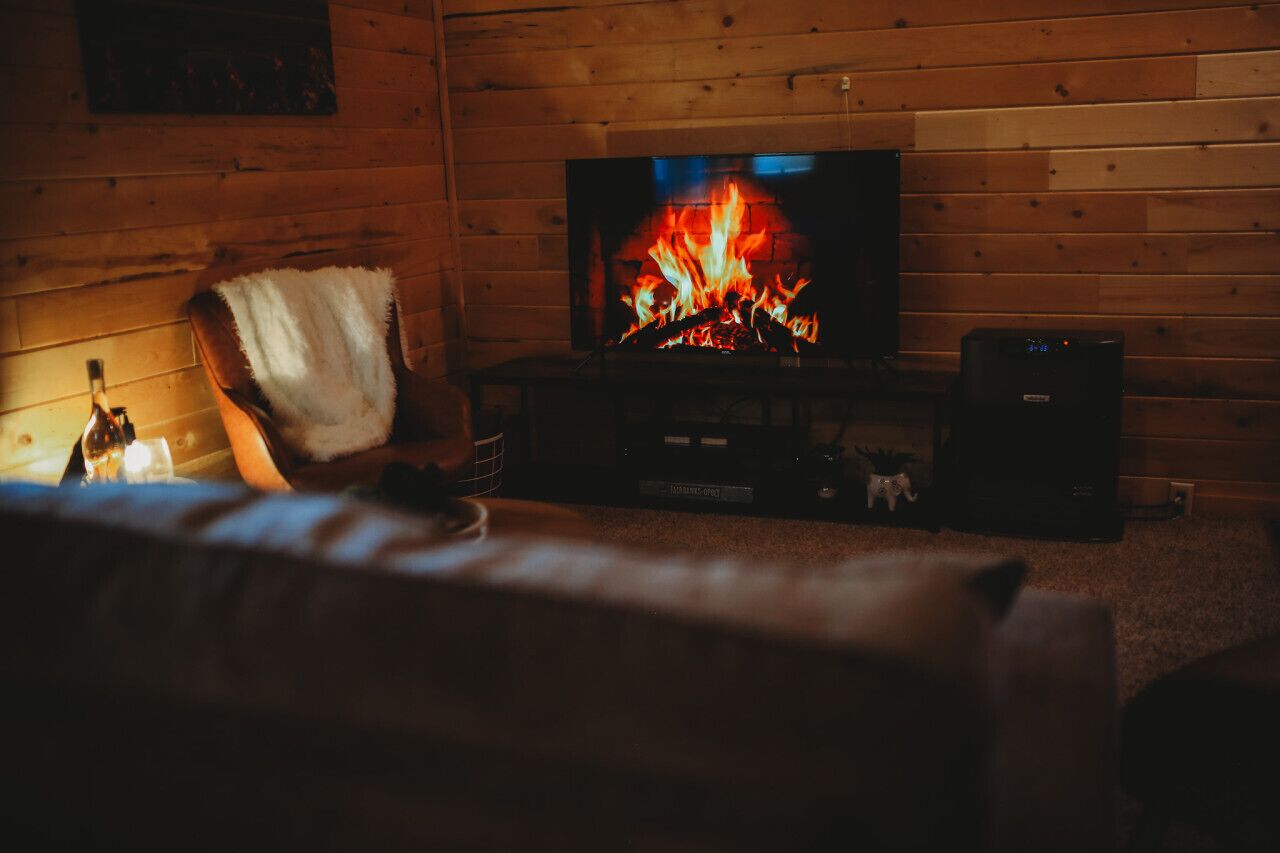 A cozy room with a fireplace, a television, and a comfortable seating area.