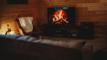 A cozy room with a fireplace, a television, and a comfortable seating area.