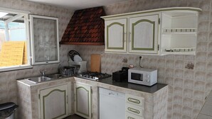 Une cuisine équipée d’une cuisinière, d’un four à micro-ondes, d’un évier et de placards.