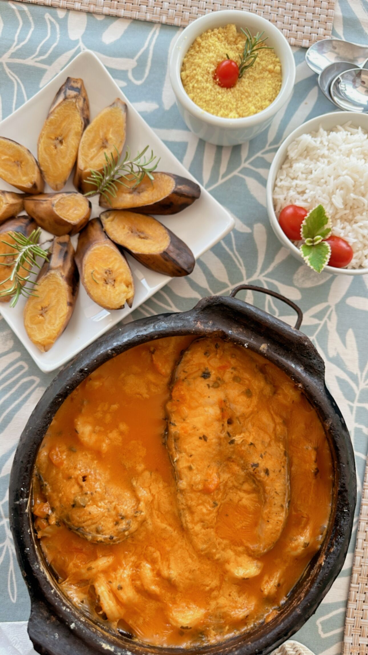 A meal with fish, sweet potatoes, rice, and a bowl of sauce.
