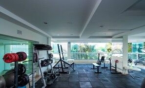 Een sportschool met krachtherinner, een bank en uitzicht op groen.