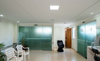 Un área de espera con un mostrador de recepción, una puerta a un cuarto privado y un bote de basura.